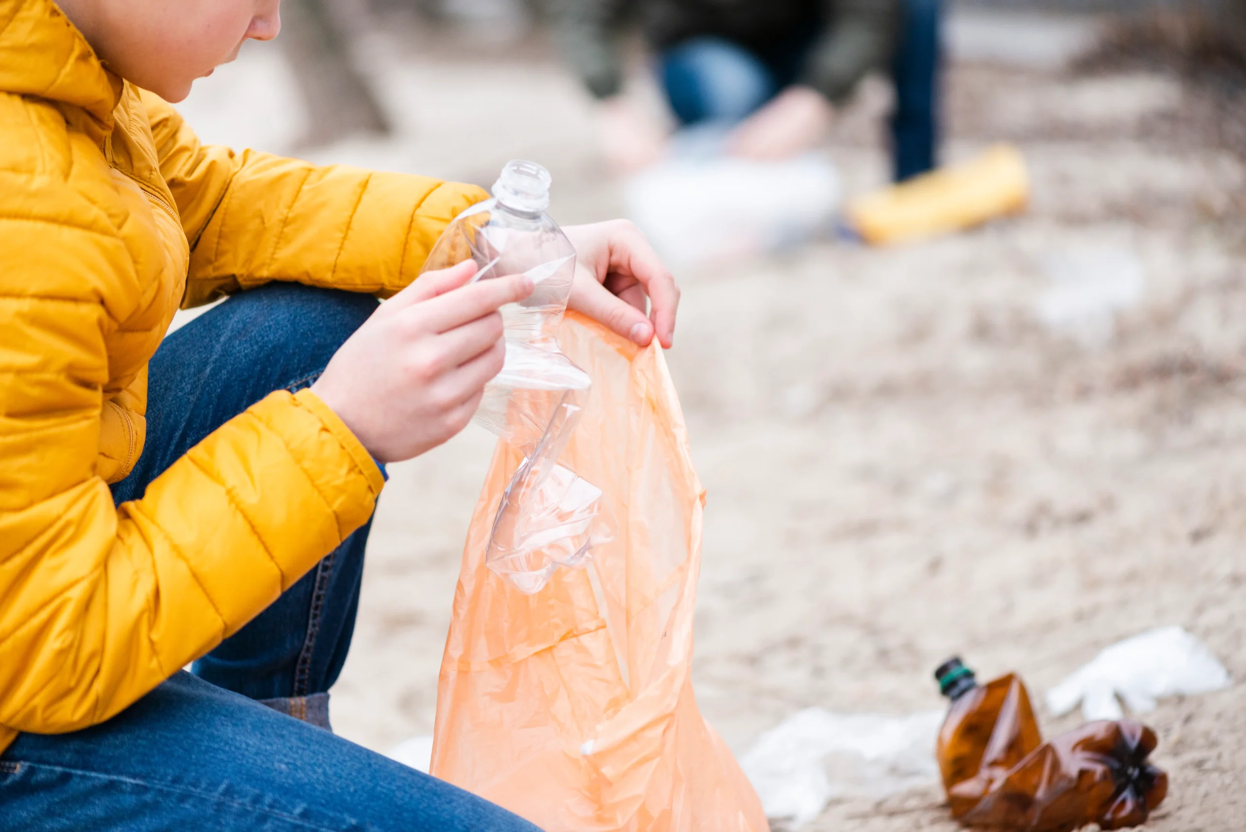 Persona recogiendo una bolsa plástica para fomentar hábitos sostenibles y reducir plásticos de un solo uso