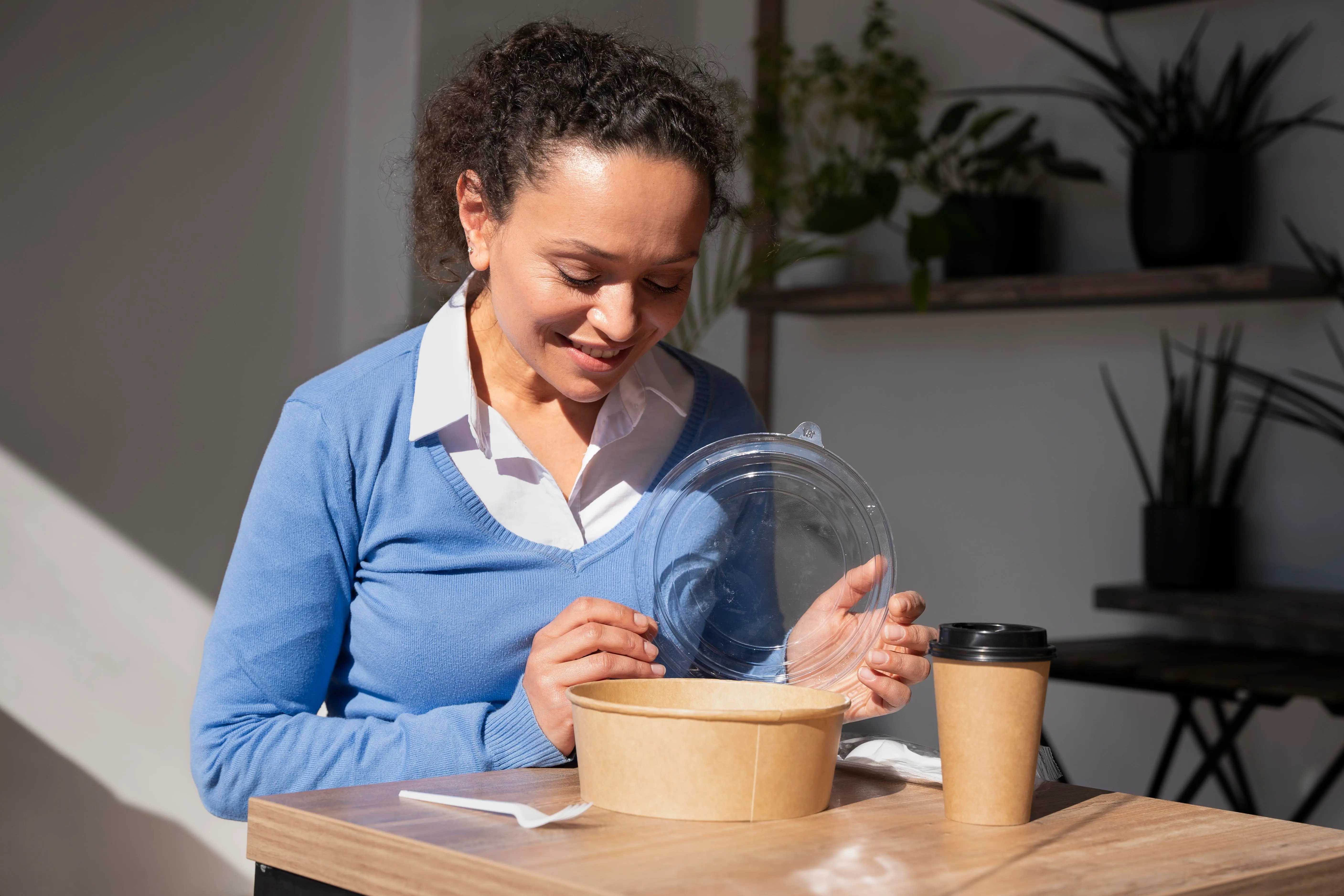 Persona utilizando envases biodegradables como parte de hábitos sostenibles para reducir residuos